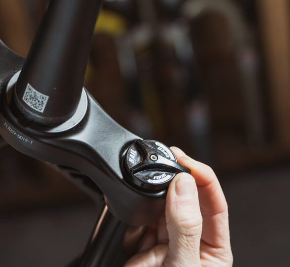 Close-up of a hand adjusting a bicycle handlebar with a blurred background