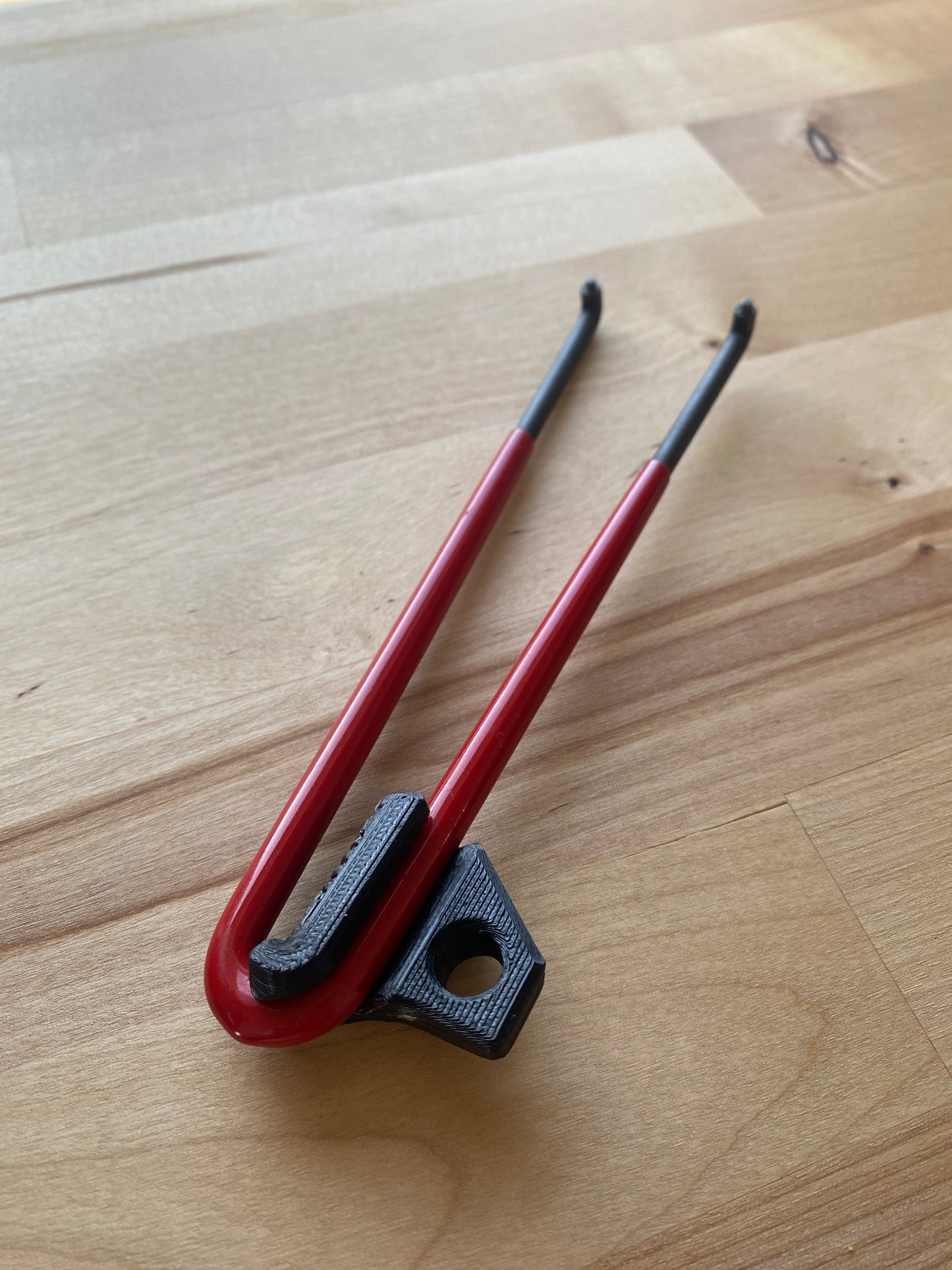 Red and black tool on a wooden surface