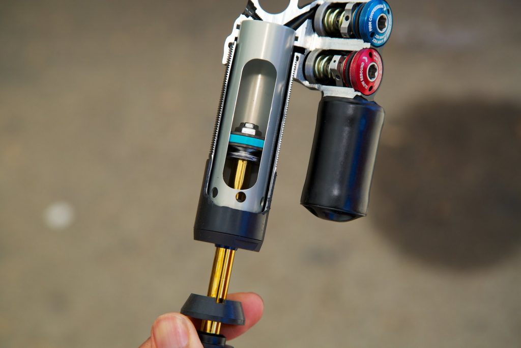 Close-up of a bicycle suspension fork with colorful components against a blurred background