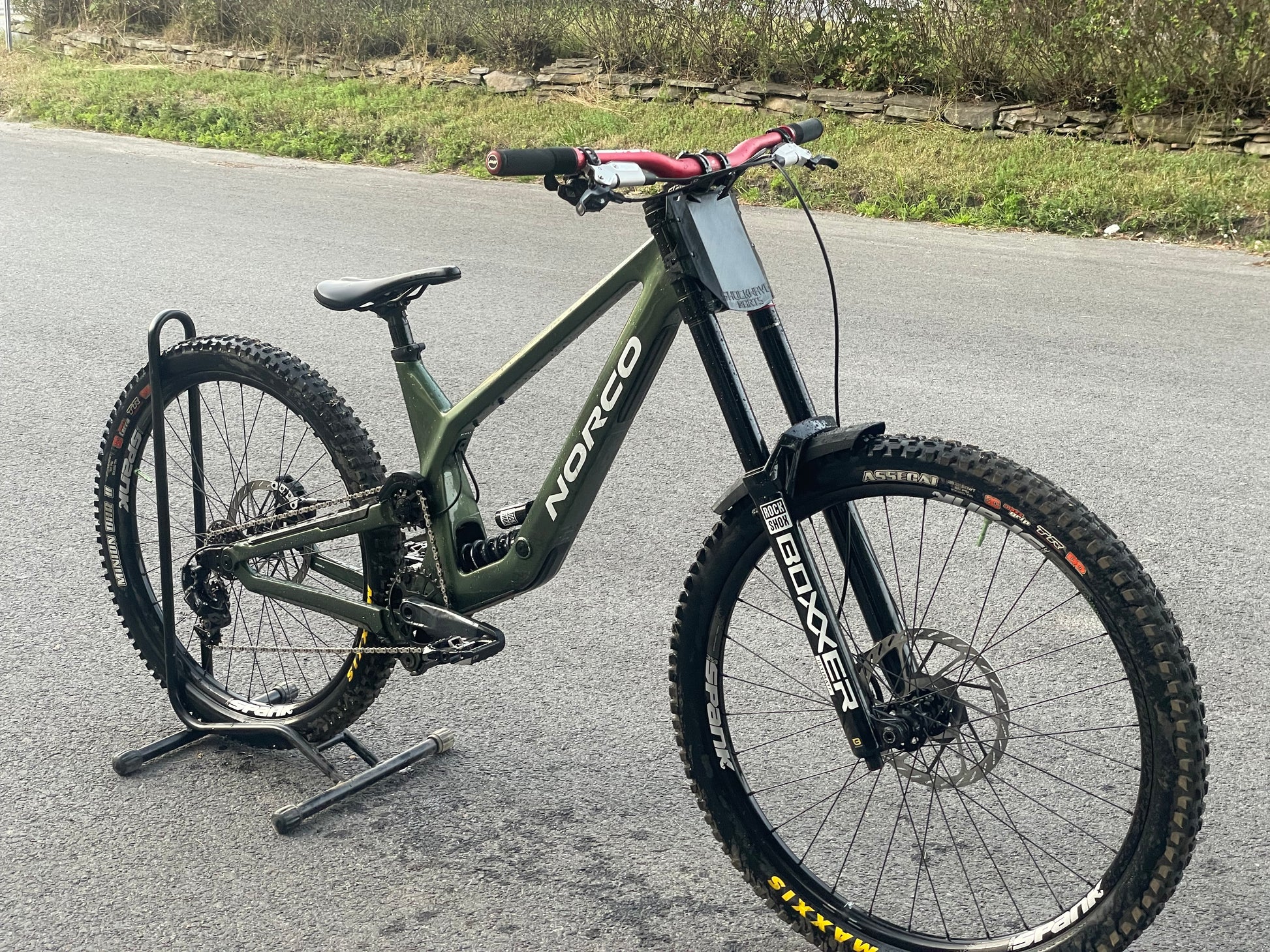 Bicycle on its side on a road with grass and pavement visible